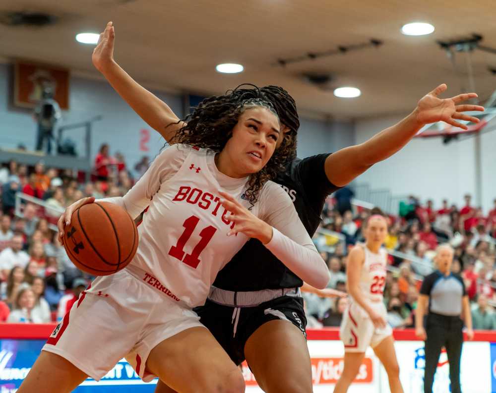 Junior forward Caitlin Weimar (11) protecting the ball from a Holy Cross player in Jan. 2024. The Terriers lost 50-61 on Monday. HUI-EN LIN/DFP STAFF
