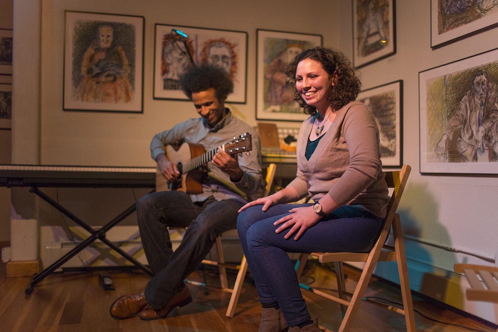 Two performers share the stage at Gallery 263 in Cambridge as they perform an original song about combating gender inequality during the Emerging Boston Area Singer-Songwriters open mic on Oct. 6. PHOTO BY RHIANNON JESELONIS/ DAILY FREE PRESS STAFF 