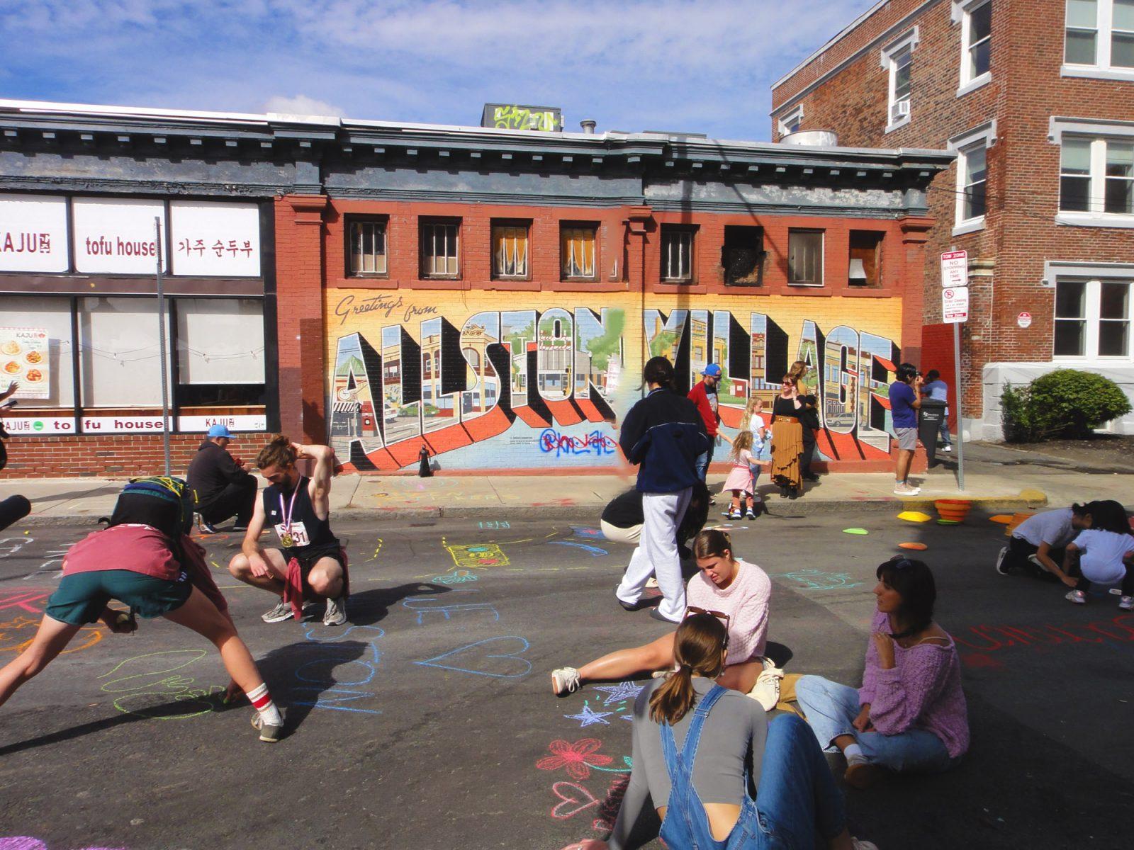 Attendees of the Allston Village Street Fair drawing on Farrington Avenue with chalk on Sunday. The festival aims to bring the community together through live performances and local vendors. PHOTO BY SIENA GLEASON