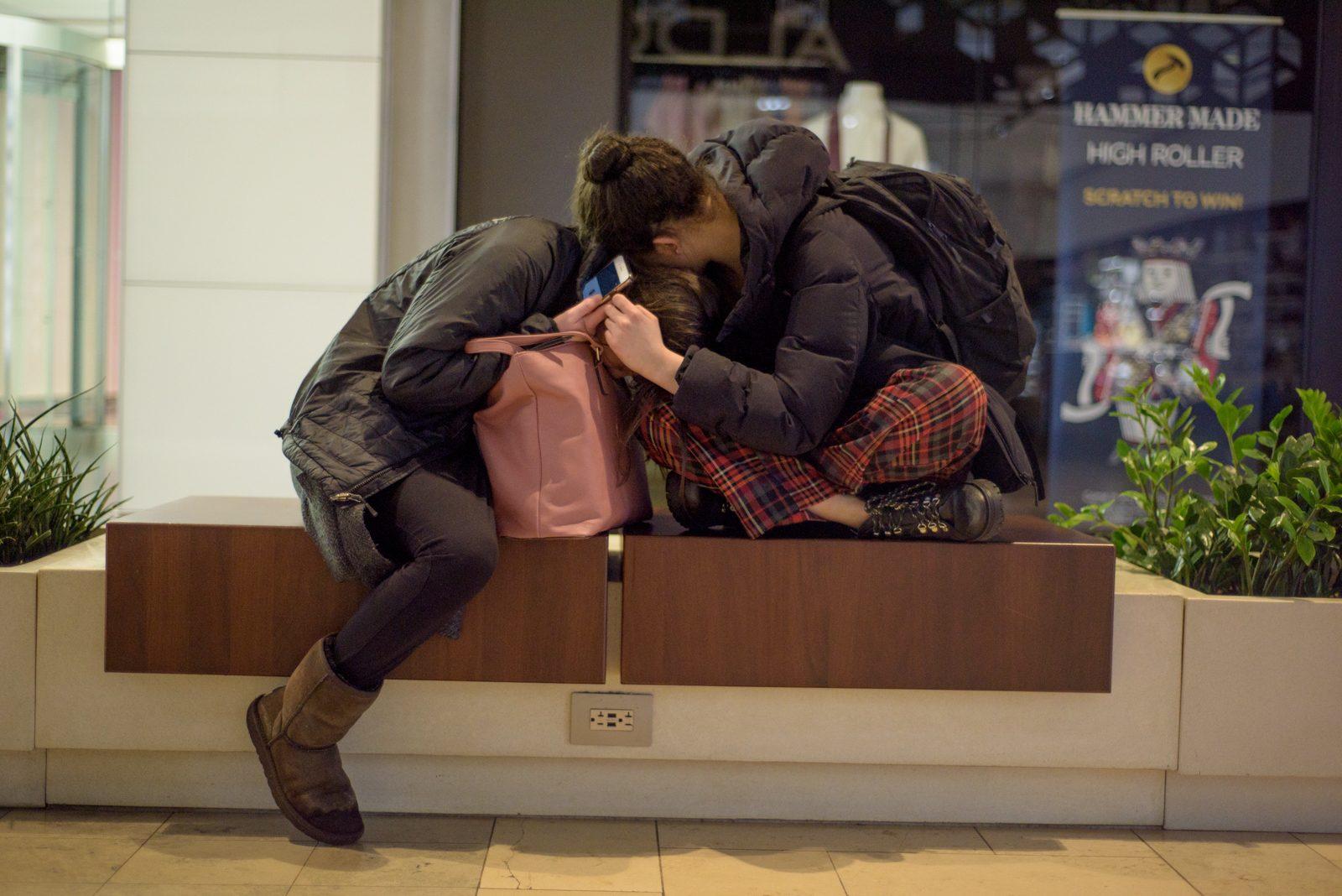 Jess and her coworker Katerina Chew embrace outside the Earl's entrance in the Prudential Center after a closing shift on Apr. 11, 2019, at around 3:20 a.m. Jess said that most of the people she socializes with are her coworkers, that a "traumatizing aspect" of going through difficult times together "forms bonds." CHLOE GRINBERG/ DFP STAFF
