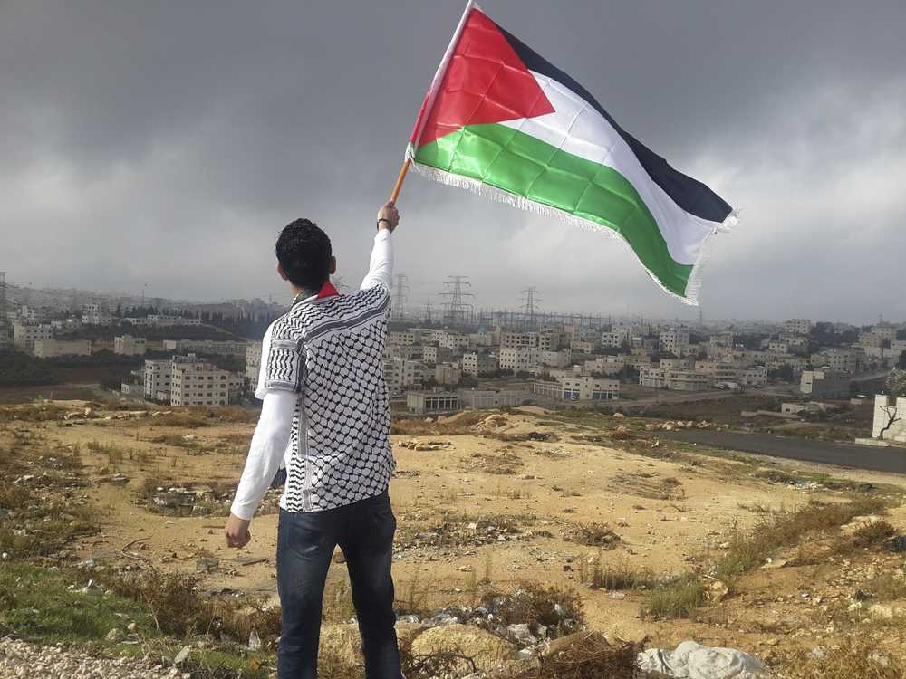 A man holds up the Palestinian flag. Eve Spangler, a professor at Boston College, gave a talk on Palestine Thursday evening. PHOTO COURTESY WIKIMEDIA COMMONS  

