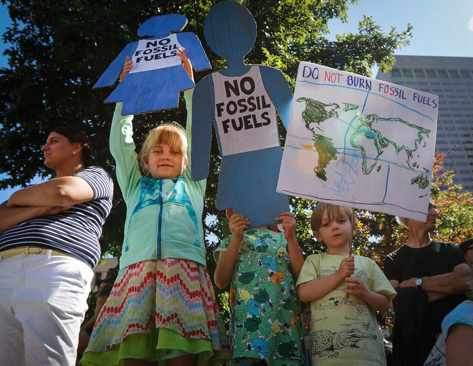 Children raise signs calling for the end of fossil fuel use at the Massachusetts Climate Strike on Friday. The Massachusetts Executive Office of Energy and the Department of Energy Resources announced on Tuesday a $14.9 million award to fund clean energy initiatives across the state. GABRIELA HUTCHINGS/ DAILY FREE PRESS STAFF