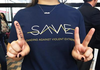 A team member from Boston University's Standing Against Violent Extremism group holds up her hands to represent the group’s #oneclickto campaign. PHOTO COURTESY ANA RINALDI