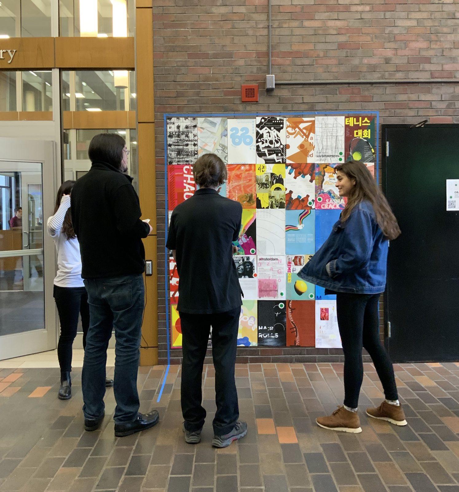 Emerson Lawton and other BU students discuss the graphic design installation Lawton's class put up in the GSU Link. COURTESY OF KRISTEN MALLIA