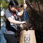 student volunteer rakes leaves at global days of service