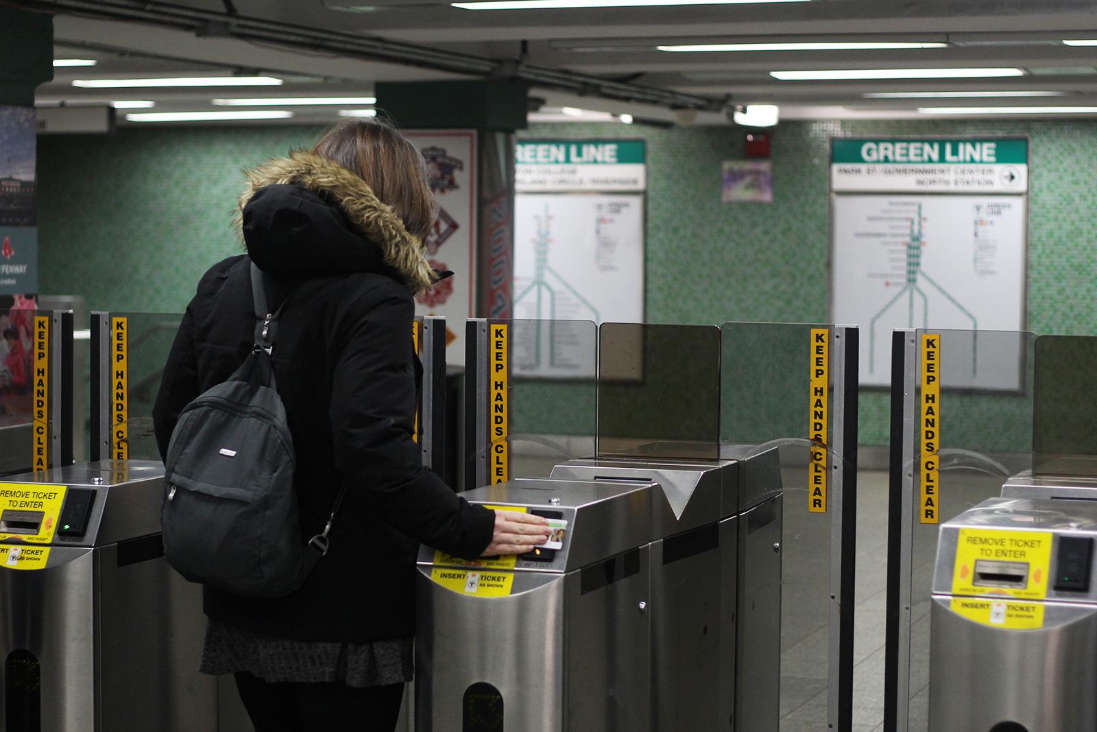 A person uses the turnstile at the Kenmore T Station. Gov. Charlie Baker has proposed lowering fines and prohibiting arrest for MBTA fare evasion over concerns that transit police disproportionately target minority groups Friday. HANNAH YOSHINAGA/ DAILY FREE PRESS