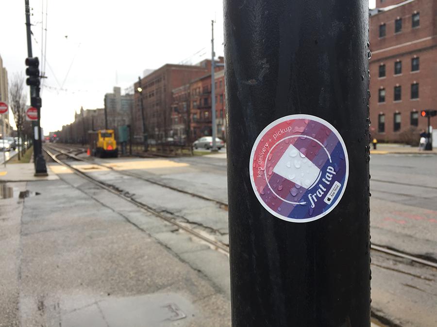 A Frat Tap sticker on Commonwealth Avenue. The company, which delivers kegs to parties, was started by BU students. PHOTO BY VIVIAN MYRON/DAILY FREE PRESS STAFF 

