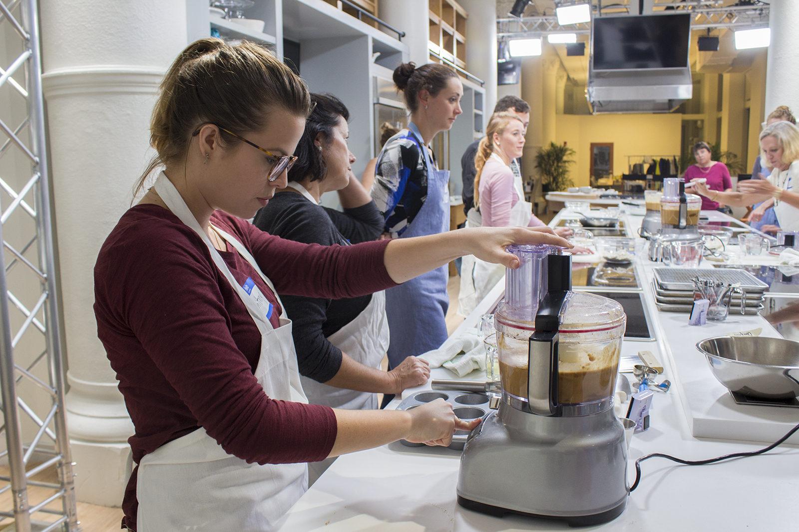 Brittany Bertrand, attendee of Milk Street's cooking class “Less, but Better: Fewer Ingredients, More Impact,” uses a mixer Wednesday night while learning how to prioritize cooking healthy meals on a budget. PHOTO BY JENNA MANTO/ DAILY FREE PRESS STAFF