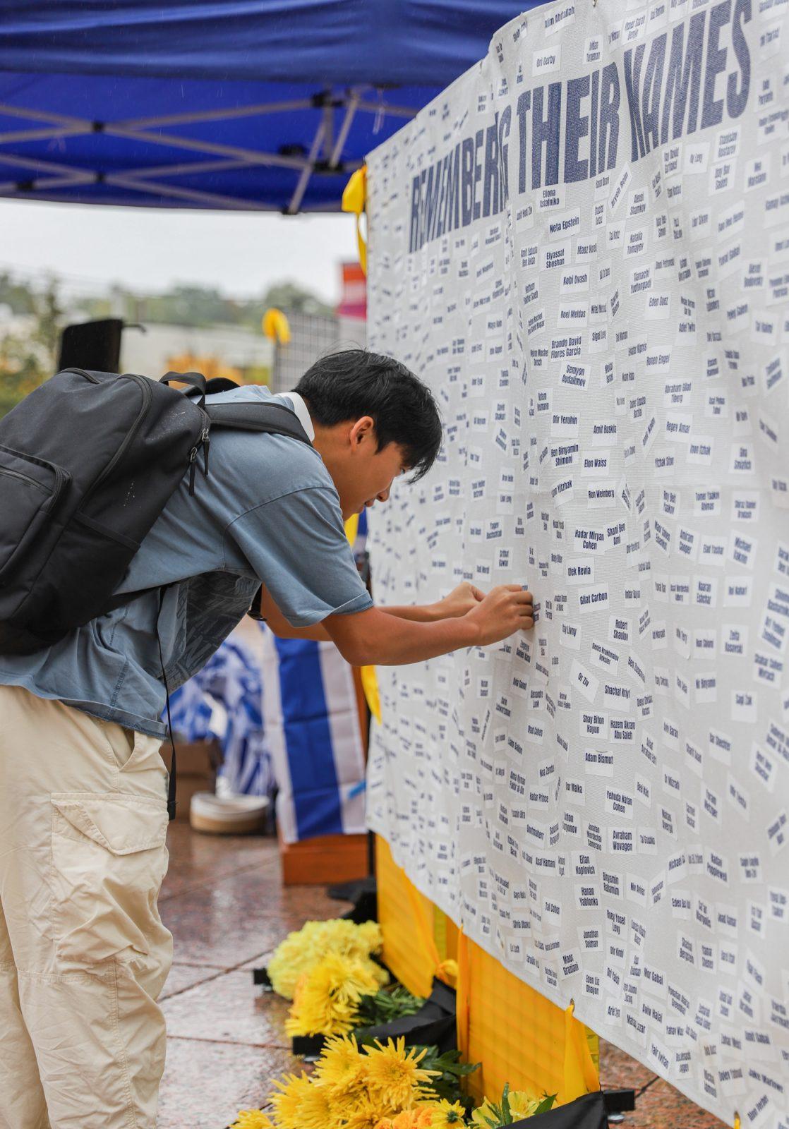 A person places a name on Boston University Hillel’s memorial at Marsh Plaza. BU Hillel and Boston University Students for Israel co-sponsored the memorial for people who died during the attack on Israel. KATE KOTLYAR/DFP PHOTOGRAPHER 