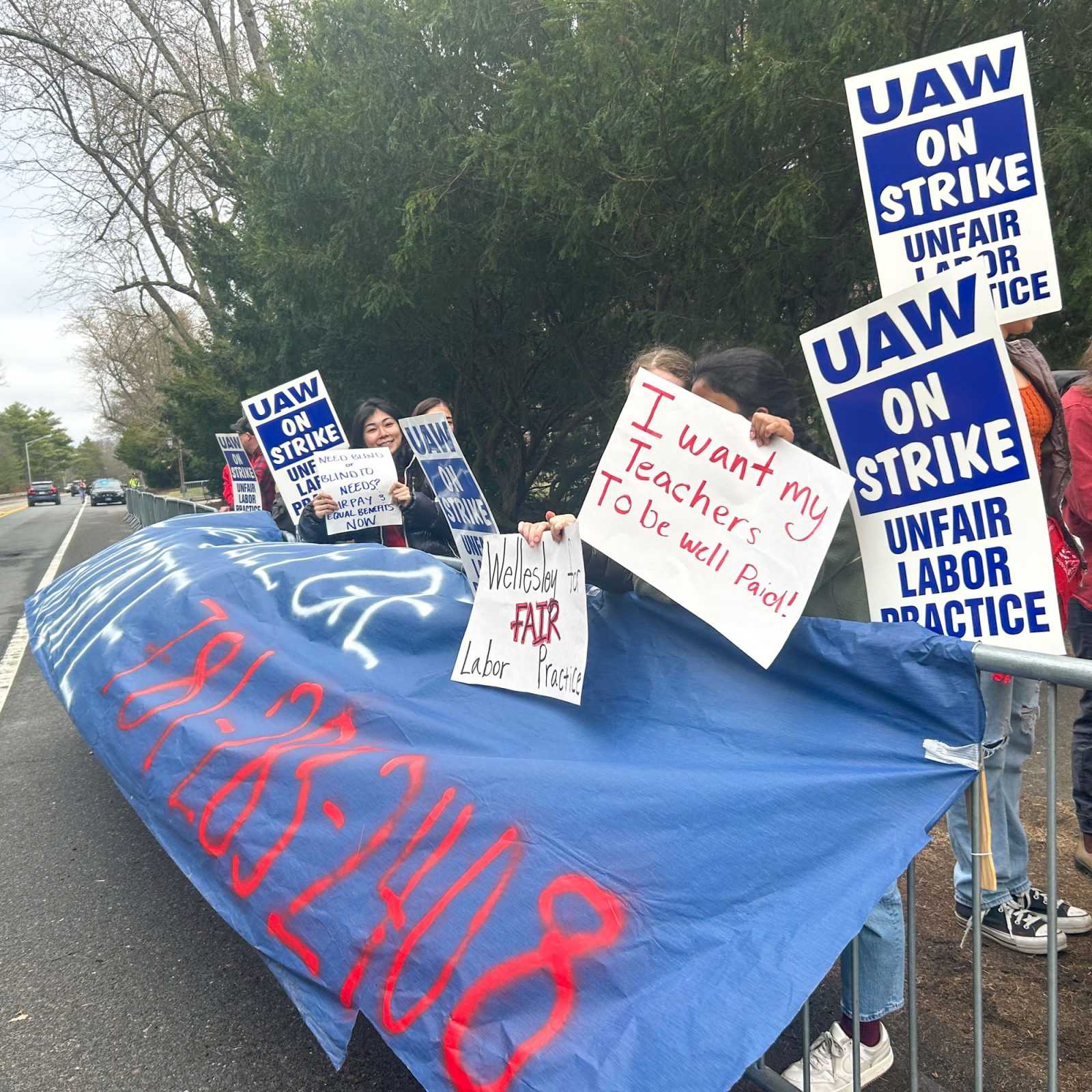 Protestors hold signs in support of the Wellesley Organized Academic Workers Union. Wellesley College’s non-tenure track faculty have been on strike since March 27 because the union and college administration could not agree on a contract. PHOTO BY ELI PEKELNY 

