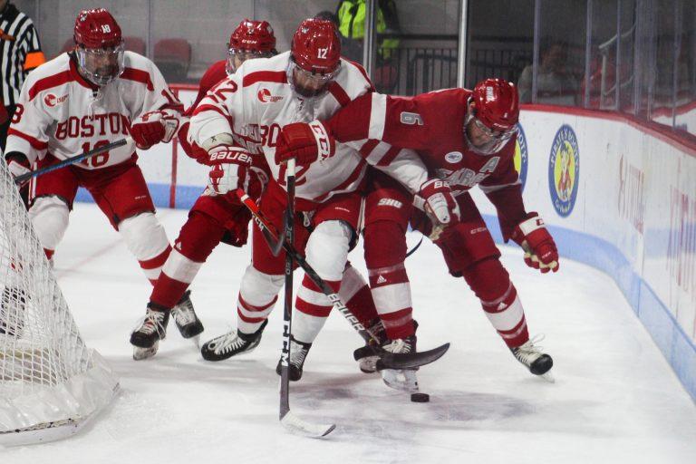 Jamie Armstrong jousts for a puck with a Pioneer on Tuesday night. Photo by Jenna VanSickle.