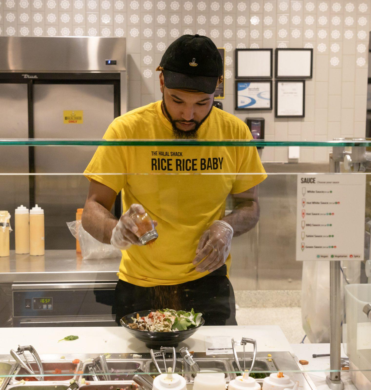 Johnny Walker, a worker at Halal Shack in the George Sherman Union, creates a bowl for a customer. Student concern has risen over increased meal prices and decreased portion sizes at the GSU. KATE KOTLYAR/DFP PHOTOGRAPHER