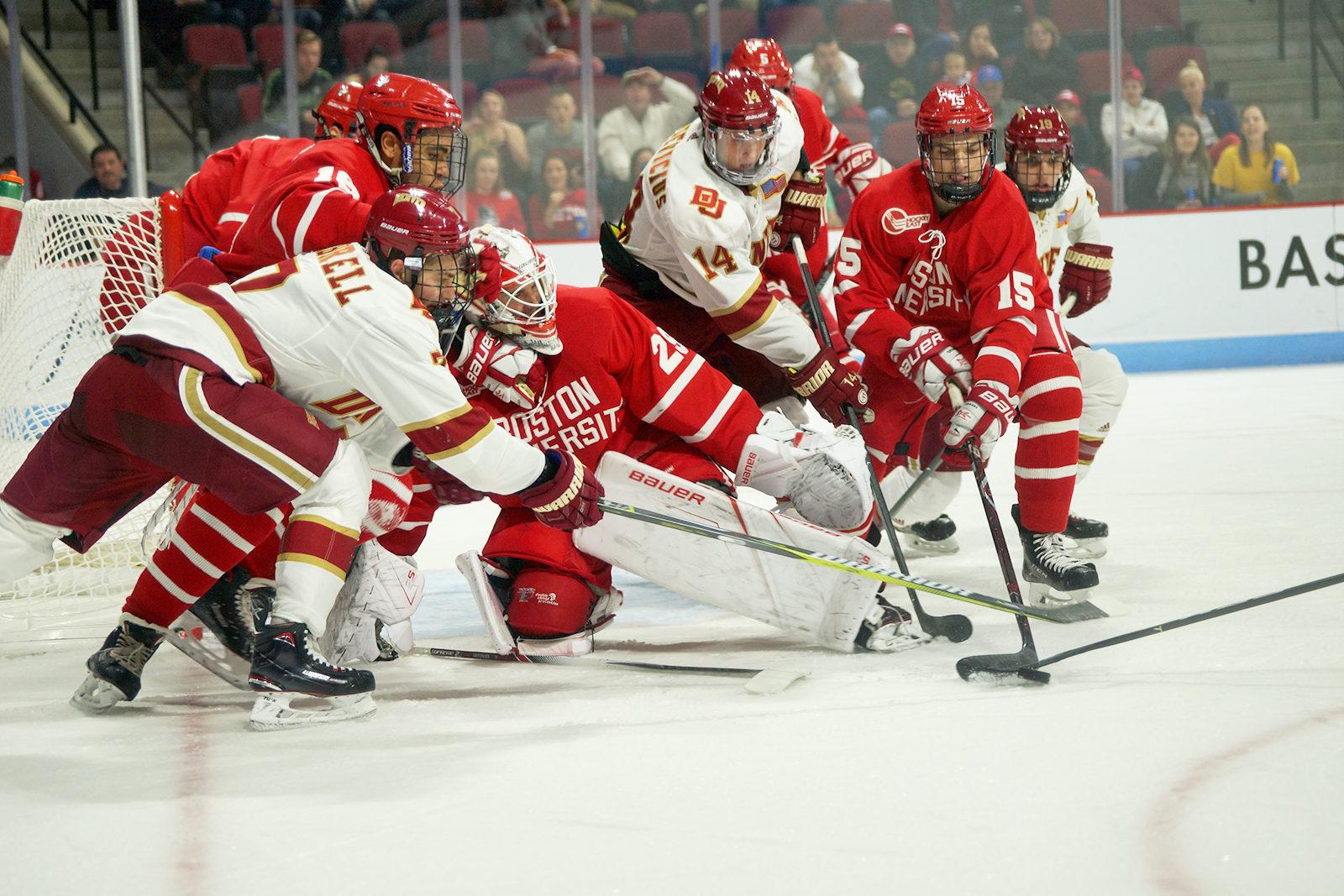 Jake Oettinger makes a save while being swarmed by Pioneers. PHOTO BY SYDNEY MAES/DAILY FREE PRESS STAFF 