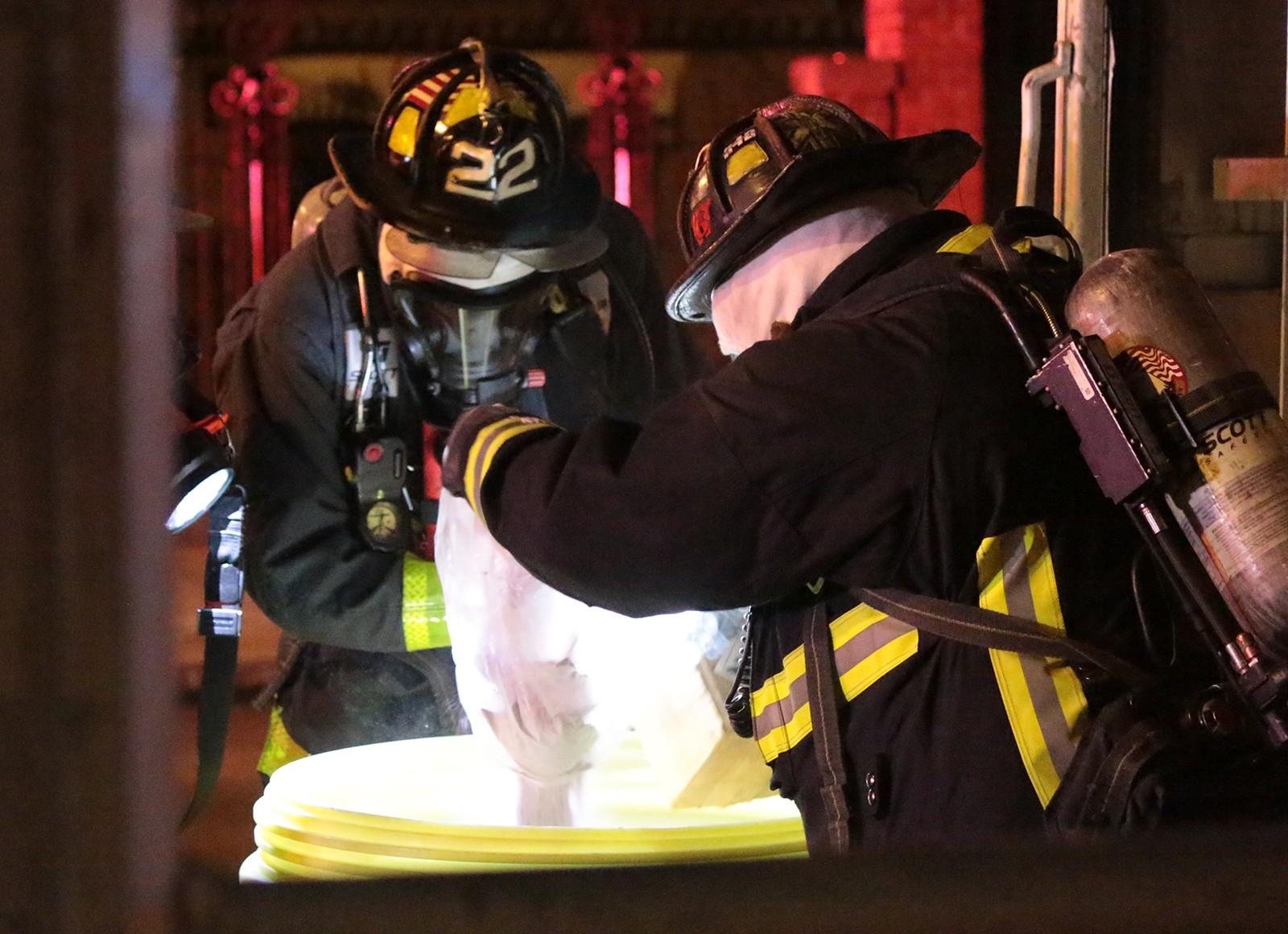 Firemen remove the leaking bottle of hydrochloric acid in a secure environment. PHOTO BY KELSEY CRONIN/DAILY FREE PRESS STAFF