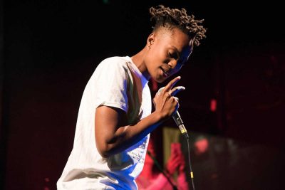 Sean Desiree, or "Bell's Roar," performs her song entitled "Black Lives" at the Rock Against the TPP concert in Jamaica Plain on Friday. PHOTO BY LAUREN PETERSON/DAILY FREE PRESS STAFF