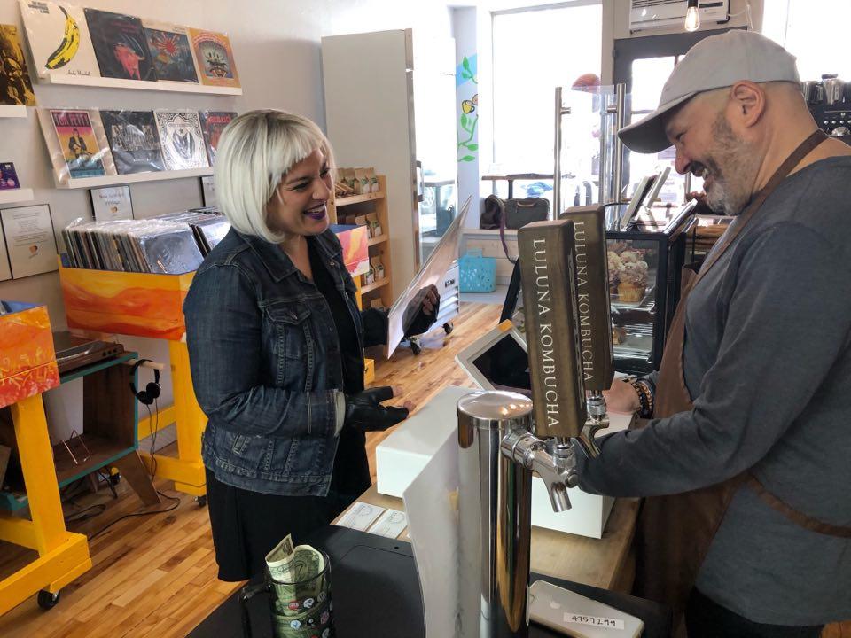 Rayna Jhaveri, lead singer of the Boston punk-funk trio Muzzins, shares a laugh with Javier Amador-Pena, the owner of the newly-opened Monumental Market in Jamaica Plain. COURTESY OF CHRIS ANTONOWICH