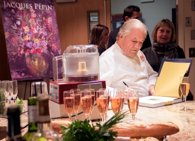 Jacques Pepin signs his book at “On Cooking and Painting,” a cooking demonstration and art show at Boston University Thursday. PHOTO BY JUSTIN HAWK/DAILY FREE PRESS STAFF
