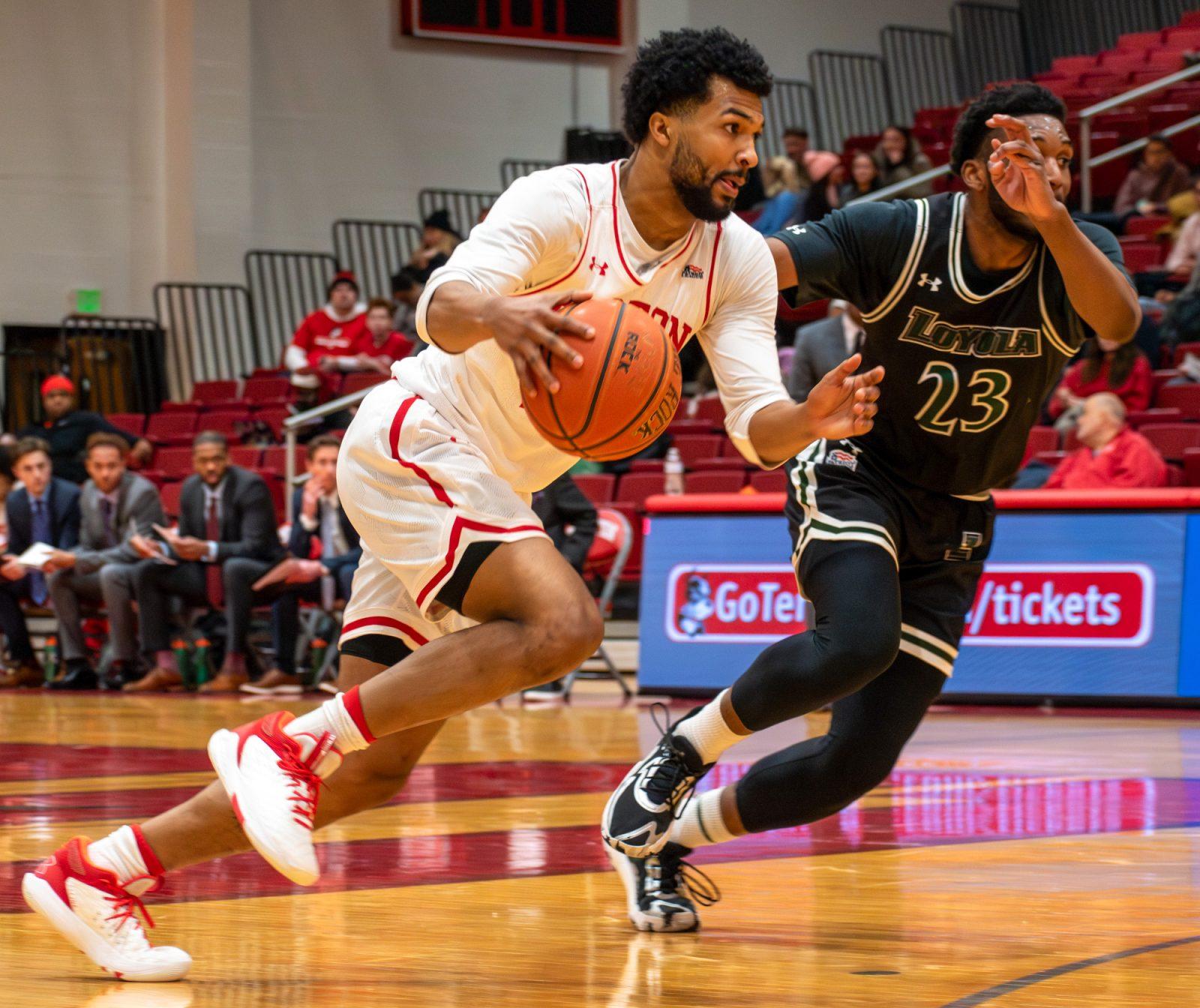 Graduate guard Miles Brewster (24) races to the net during a game against Loyola Maryland Feb. 19. The Boston University Terriers fell short of a comeback against No. 5 Navy in the 2025 Patriot League Quarterfinals with a score of 86-78. JOHN DOWNES/DFP PHOTOGRAPHER 