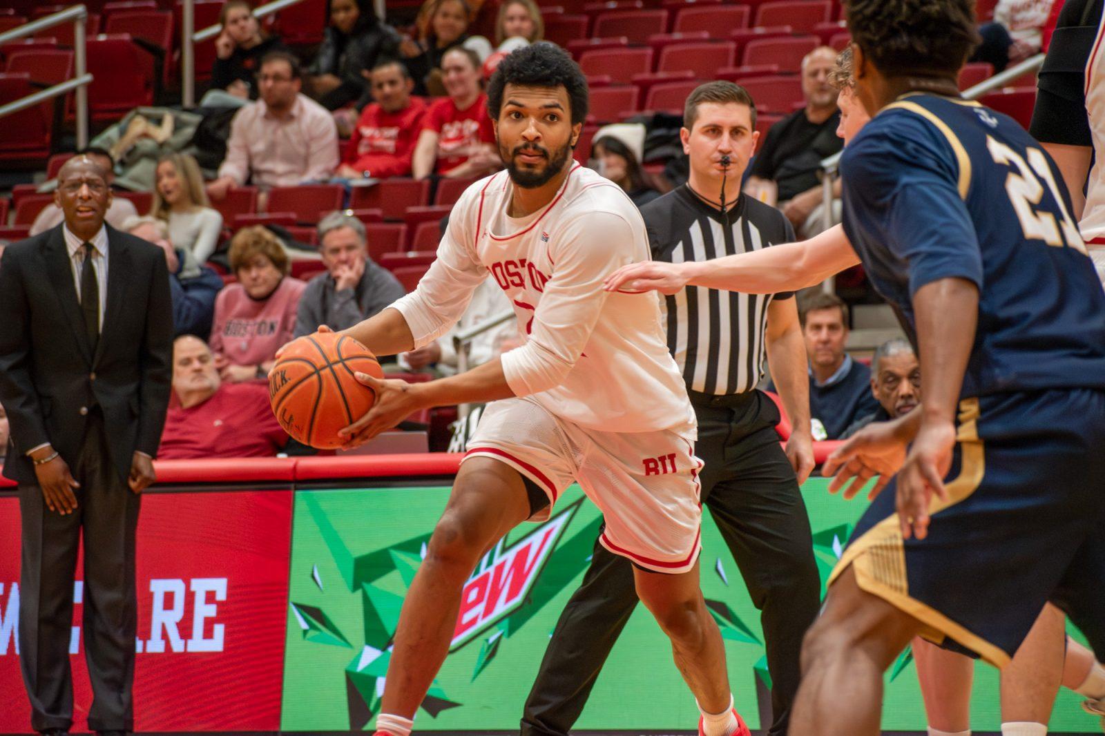Graduate student guard Miles Brewster (24) dribbles the ball by a Navy player on Feb. 5. The Boston University men’s basketball team fell to Holy Cross 72-52 on Saturday. JOHN DOWNES/DFP PHOTOGRAPHER 
