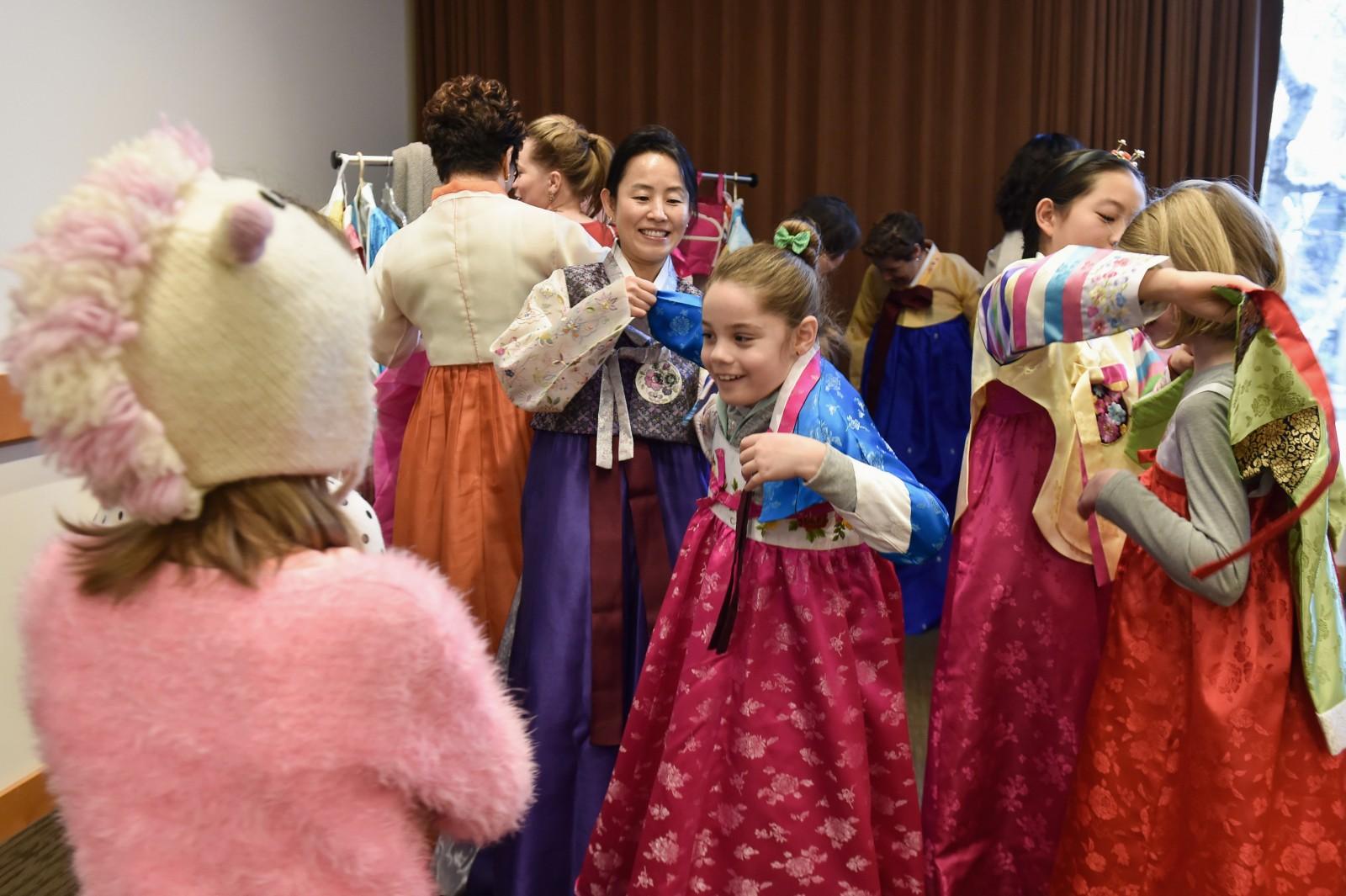 After watching a demonstration of traditional bowing and greeting, a group of young girls try on traditional Korean dresses at the free Lunar New Year Celebration at the Museum of Fine Arts Saturday afternoon. PHOTO BY MADDIE MALHOTRA/DAILY FREE PRESS STAFF