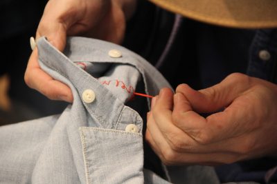 Kitten Grace, 30, completes a hand stitching for a Madewell customer. PHOTO BY SOFIA FARENTINOS/ DAILY FREE PRESS STAFF