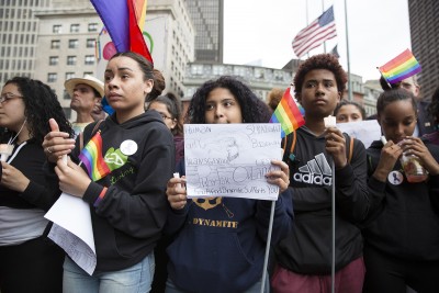 At a vigil at Boston’s City Hall Plaza Monday evening, people hold signs and rainbow flags in a show of solidarity for the victims of the mass shooting at a gay night club in Orlando, Florida. PHOTO BY SARAH SILBIGER/ DAILY FREE PRESS STAFF