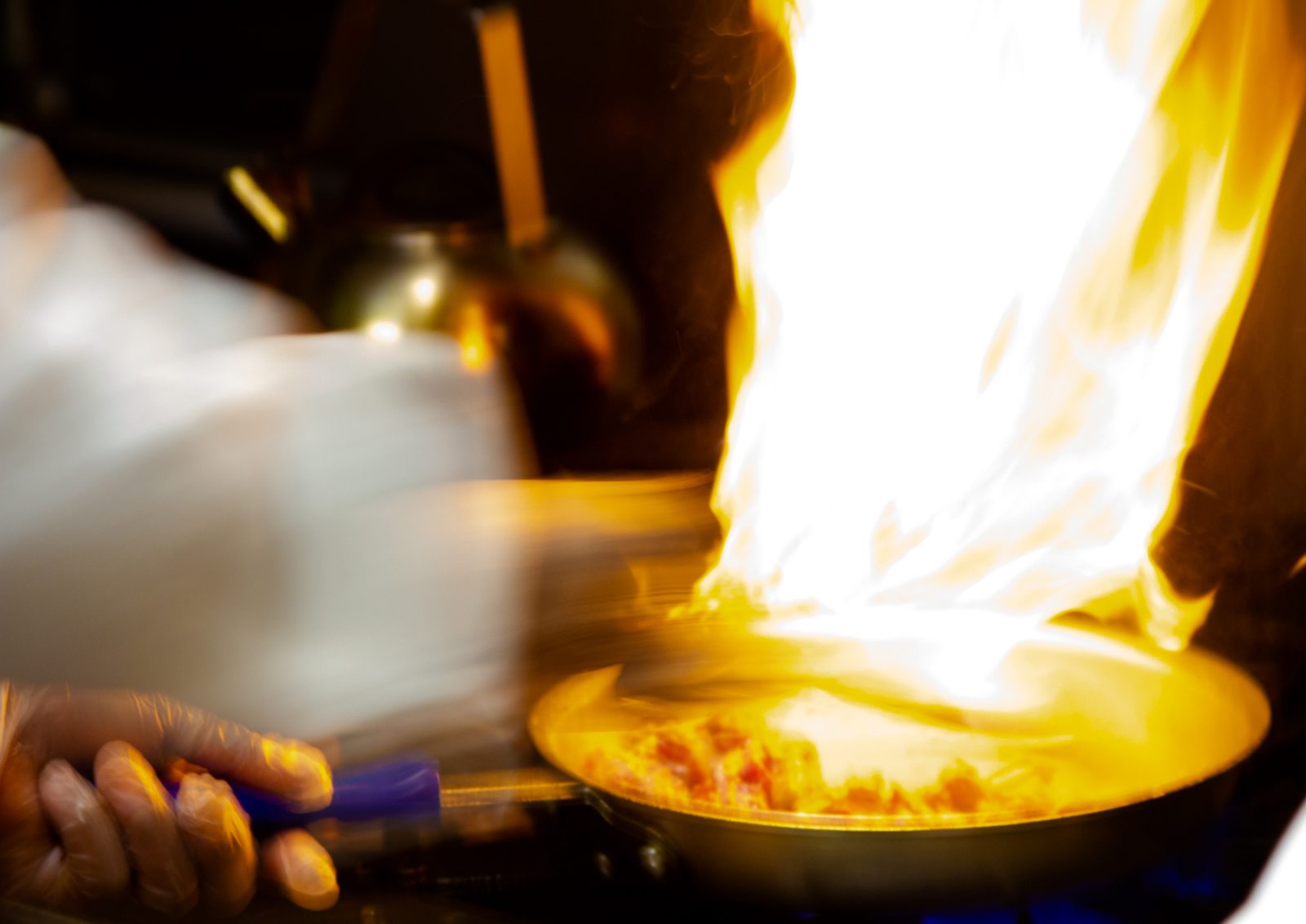 A chef extinguishes a stovetop flame at Blue Nile restaurant