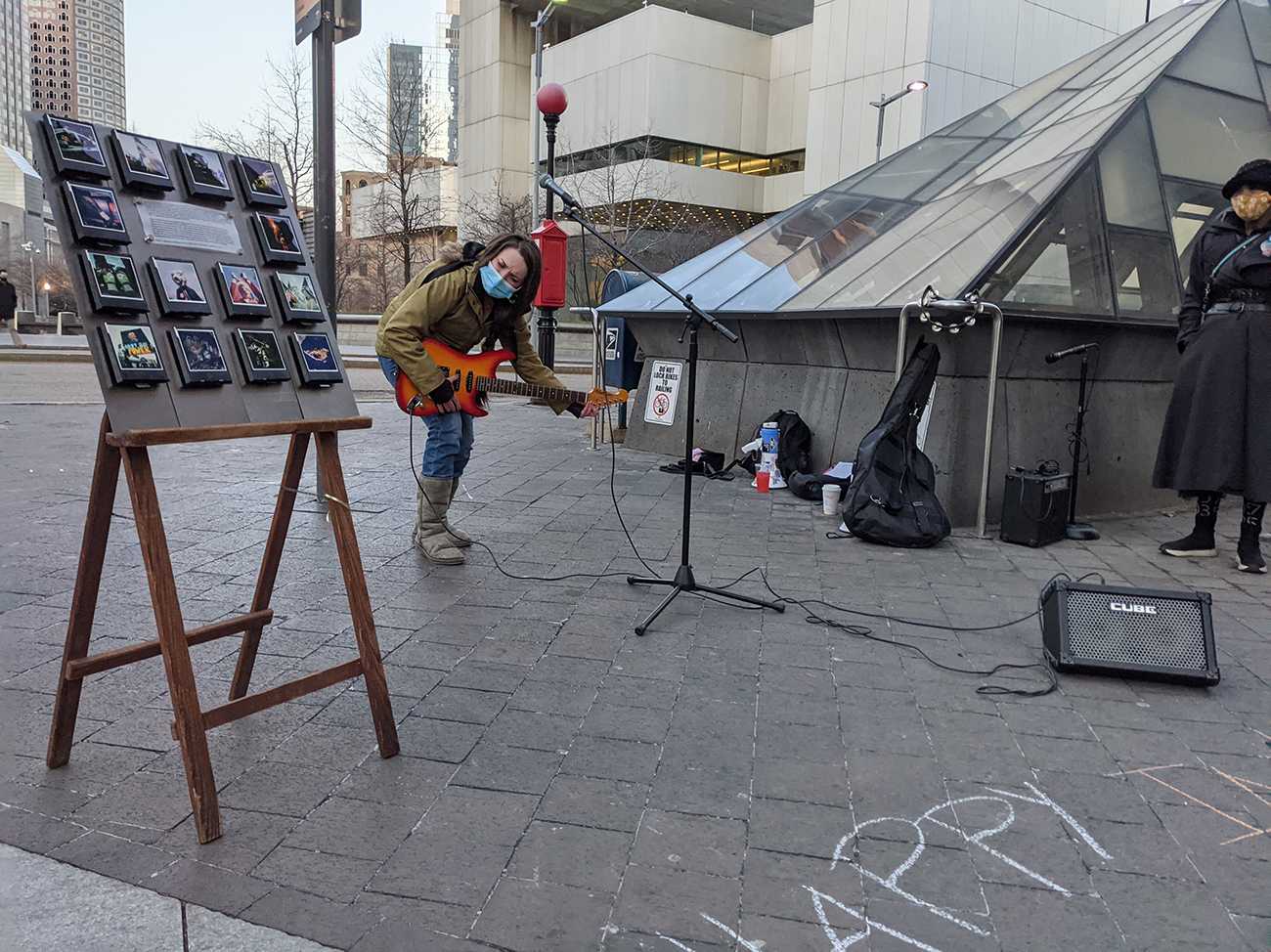 Musician Haley Martin tunes her guitar before a brief set. Activists gathered outside South Station Monday afternoon for a rally honoring International Women’s Day. DANIEL KOOL/ DAILY FREE PRESS STAFF