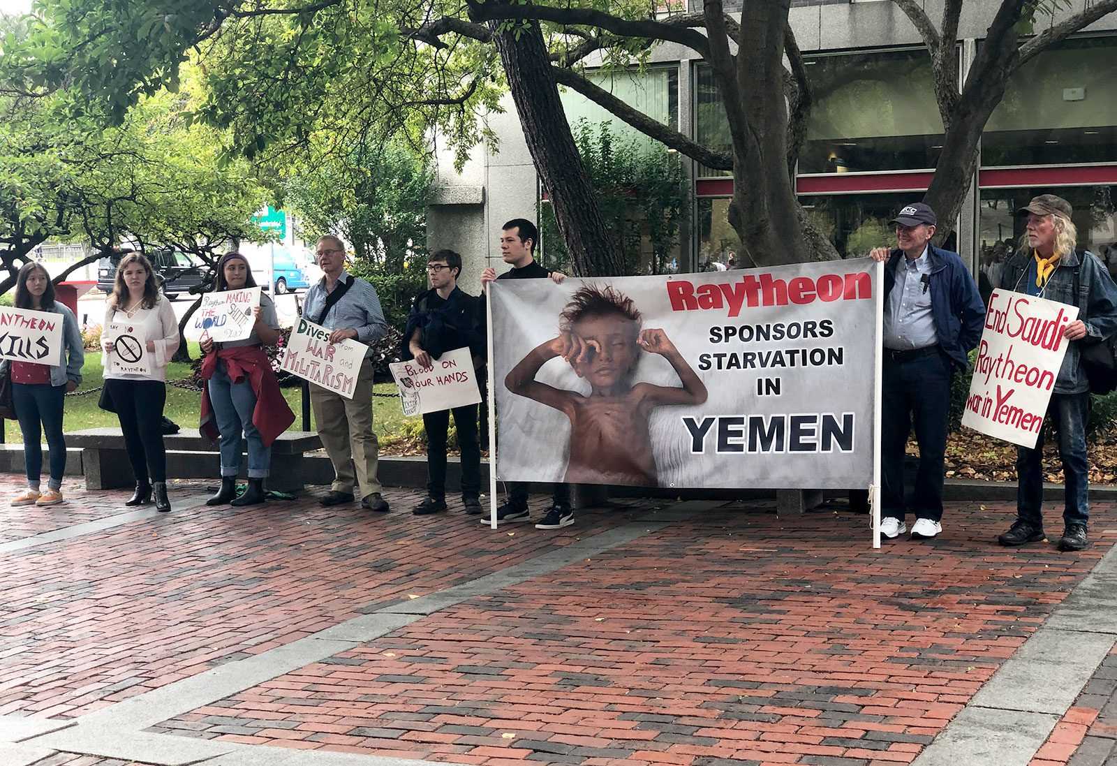 Protestors stand outside of the George Sherman Union with signs calling attention to the defense contractors being represented at the College of Engineering’s career fair taking place in Metcalf Ballroom. COURTESY OF CHANCE CHARLEY