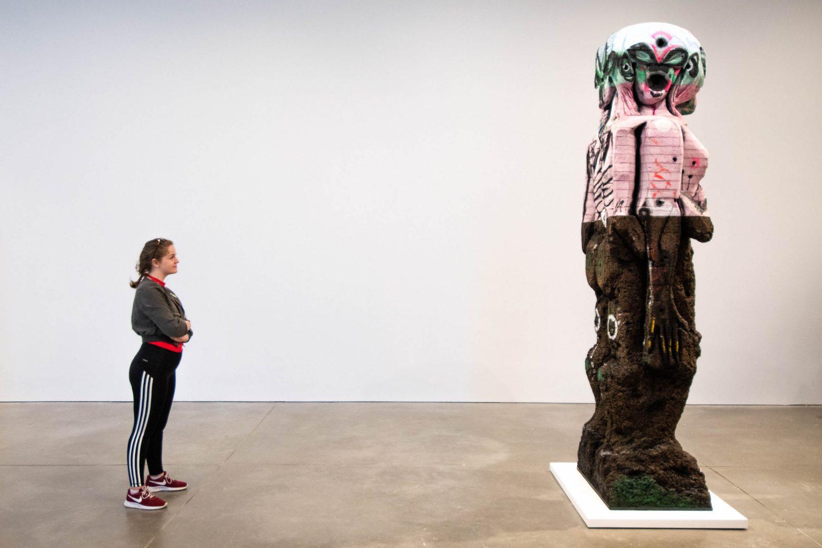 Allia Langill stands facing artist Huma Bhabha’s sculpture, “Waiting for Another Game,” on display at the Institute of Contemporary Art. RYAN GREGORY/ DFP STAFF 