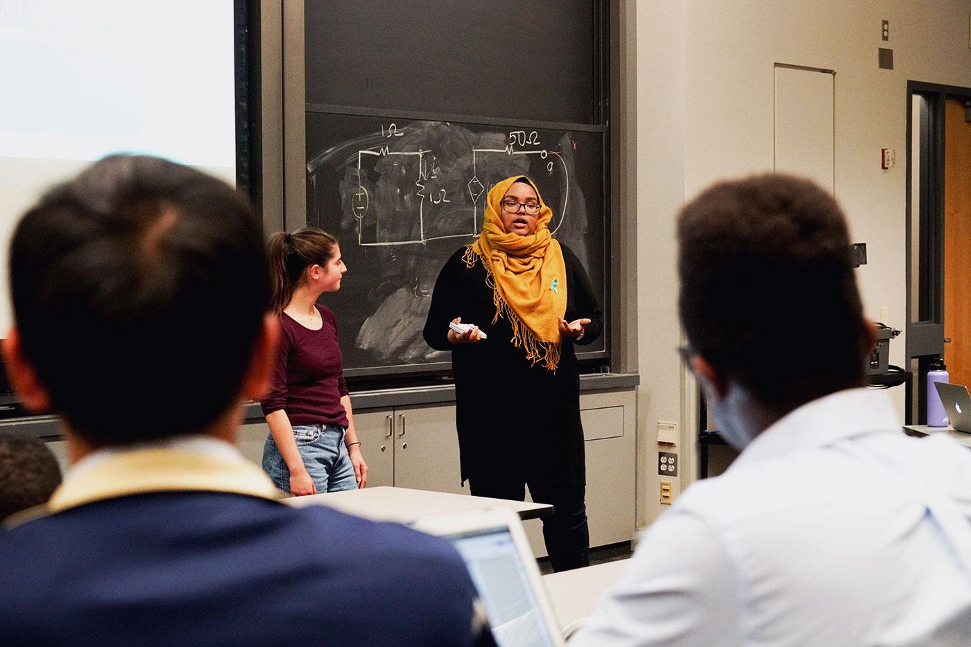Nora Stolzman (left) and Lul Mohamud (right), both newly appointed committee heads of 16,000 Strong, address senators at Monday night’s meeting. PHOTO BY SERENA YU/ DAILY FREE PRESS STAFF