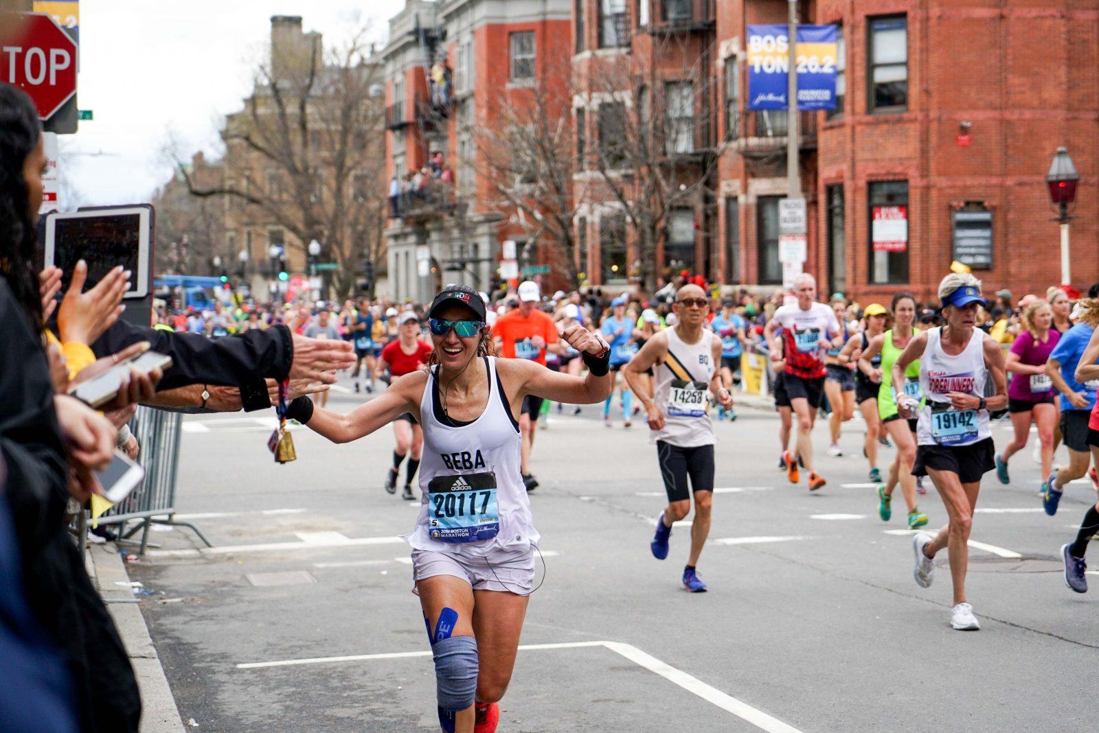  Bertha Vazquez, 40, runs toward people reaching out for high-fives during the race. SERENA YU/ DFP STAFF 