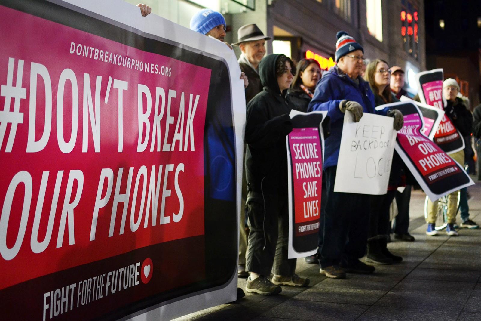 Protesters stand outside the Apple Store Tuesday night to show their opposition to the FBI in the FBI-versus-Apple controversy. PHOTO BY SAVANAH MACDONALD/DAILY FREE PRESS STAFF