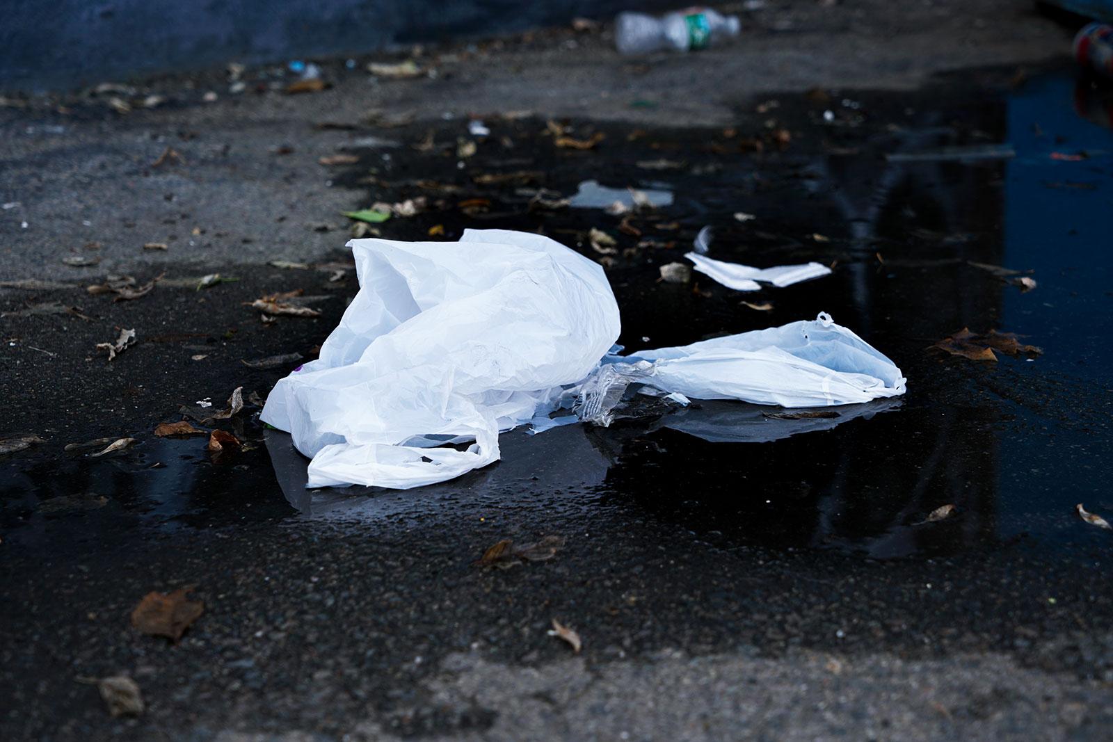 A discarded plastic bag lies in a puddle. Boston has lifted its ban on plastic bags for essential businesses and suspended fees for customers buying them in order to prevent the spread of the coronavirus. SERENA YU/ DFP FILE
