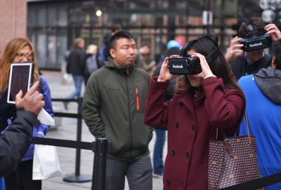 A woman peers through a pair of Samsung Gear virtual reality goggles during Facebook’s VR Tour in Faneuil Hall Marketplace. PHOTO BY SHANE FU/ DAILY FREE PRESS STAFF