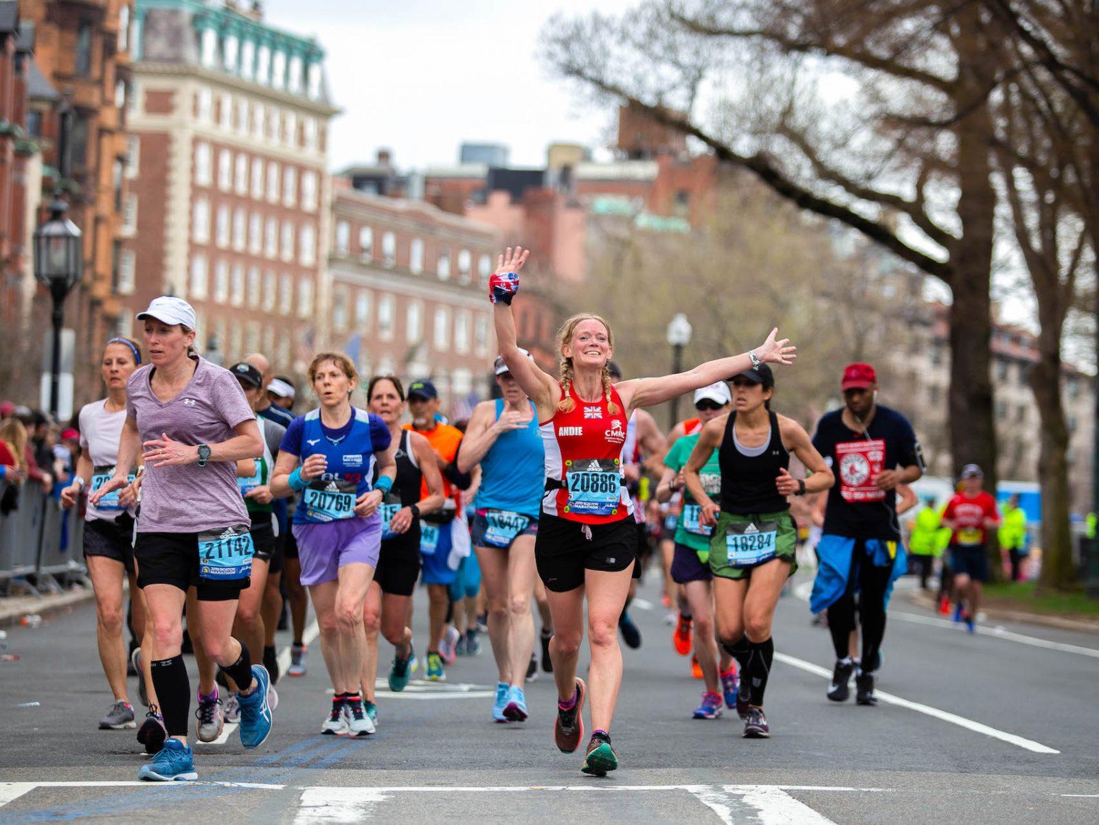 Andrea Ford, 45, from England throws her hands into the air while running the Boston Marathon in 2019. For the first time in its 124-year history, the Marathon has been canceled. 
SOPHIE PARK/ DFP FILE
