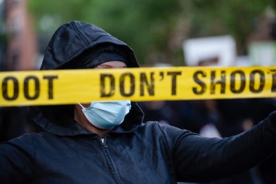 protestor holding don't shoot yellow tape