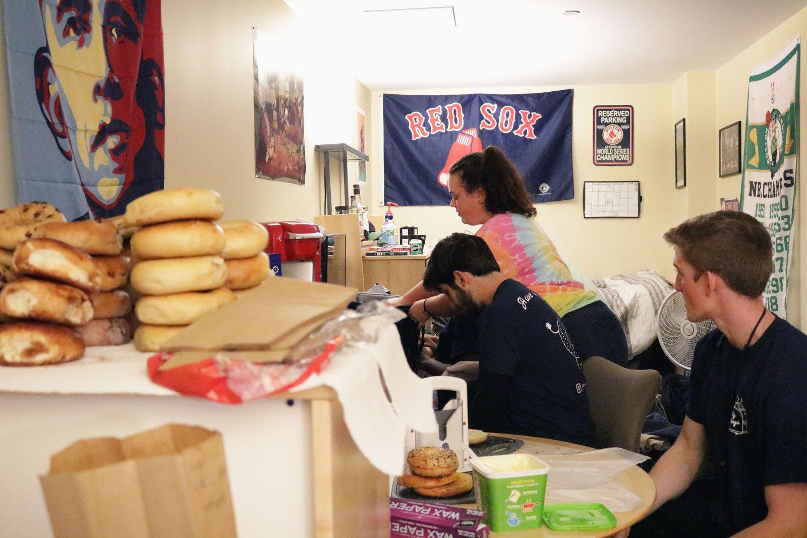 From front to back: Adam Hunter, Bruno Auriemo and Ilana Basman prepare bagel orders in a room at Boston University’s Student Village 2. SOFIA KOYAMA/ DAILY FREE PRESS STAFF