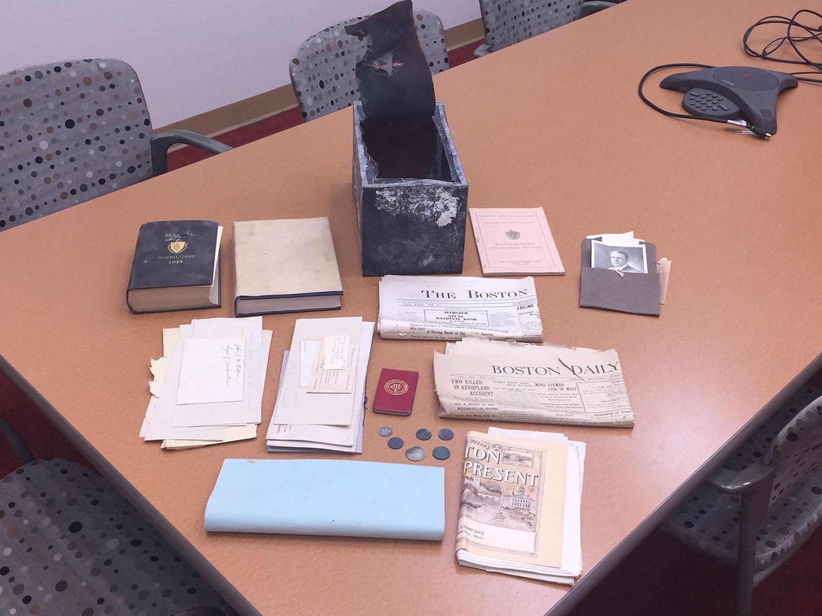 Students working for Boston University’s Facilities Management and Planning department find a time capsule from 1915 that contains maps, coins and newspapers from World War I. PHOTO COURTESY JEFFREY A. HOSETH