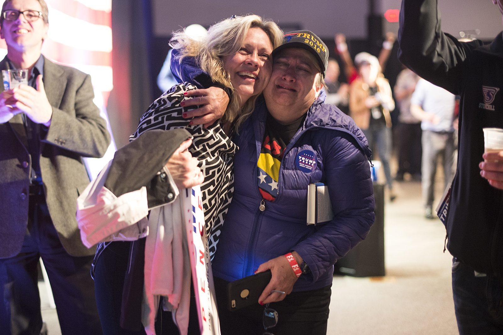 Susan Tittle (left) embraces Debbie Makowski as election results are reported on Fox News during the Massachusetts Trump-Pence Campaign victory party in Braintree. PHOTO BY MIKE DESOCIO/ DAILY FREE PRESS STAFF 