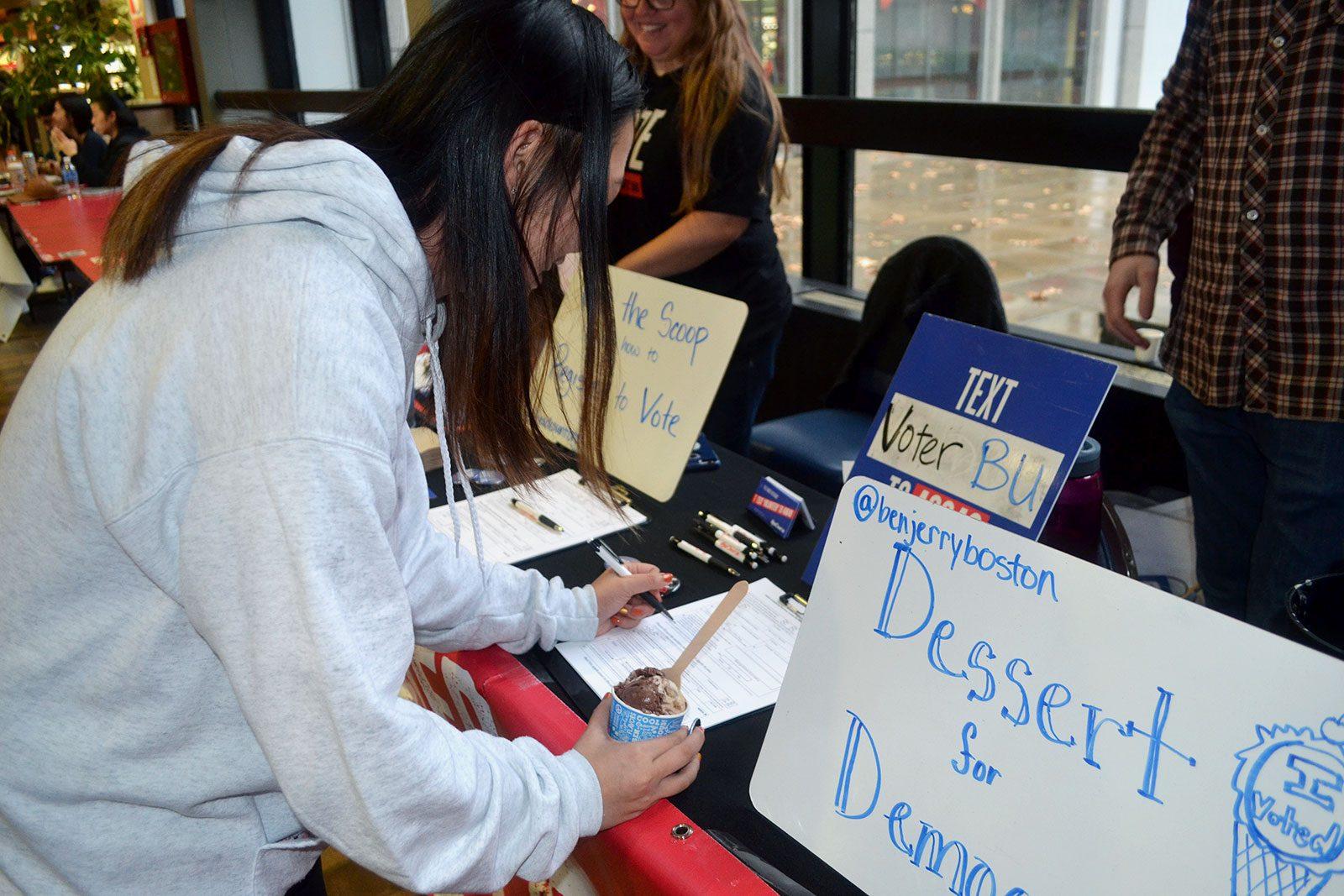 Sophie Li (CAS ‘23) fills out paperwork at a voter registration event Friday sponsored by ice cream company Ben & Jerry's at the George Sherman Union. CAROLINE FERNANDEZ/ DAILY FREE PRESS STAFF