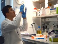 boston university student researcher handles equipment in a laboratory