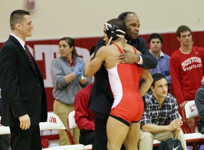 Carl Adams, former Boston University wrestling head coach, hugs Nestor Taffur, former captain, at the last meet before the wrestling program was cancelled. PHOTO BY MICHELLE JAY/DFP FILE PHOTO 