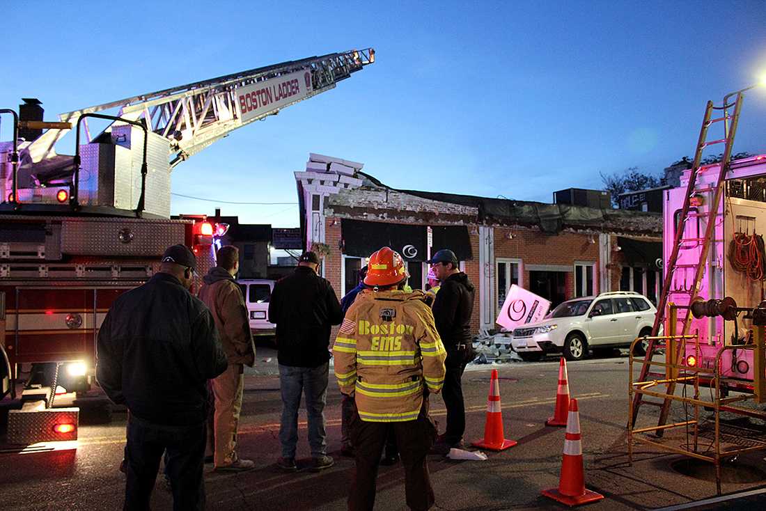 First responders assess the damage of a roof collapse at 85 Harvard Ave. Sunday evening. RACHEL SHARPLES/ DAILY FREE PRESS STAFF