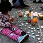 child holding a candle at the newton asian community vigil