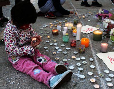 child holding a candle at the newton asian community vigil