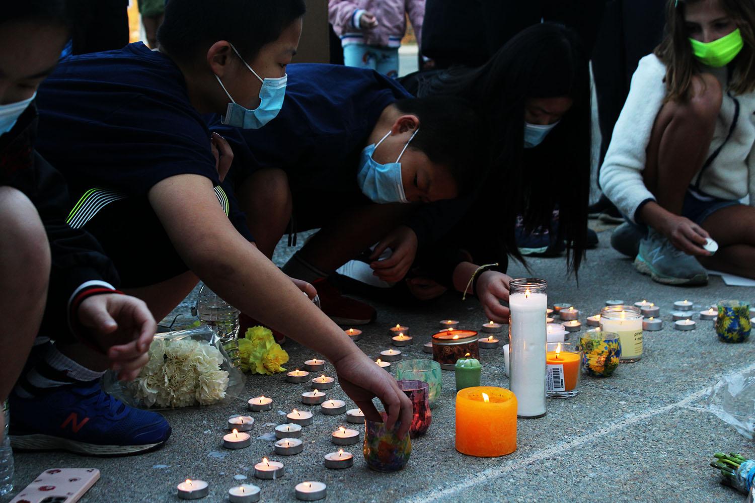 children light candles at a stop asian hate protest