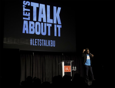 Keynote speaker and comedian W. Kamau Bell speaks about his mixed race children during “Let’s Talk About It,” a dialogue about race, identity and social action, on Monday night. PHOTO BY BRITTANY CHANG/DAILY FREE PRESS CONTRIBUTOR