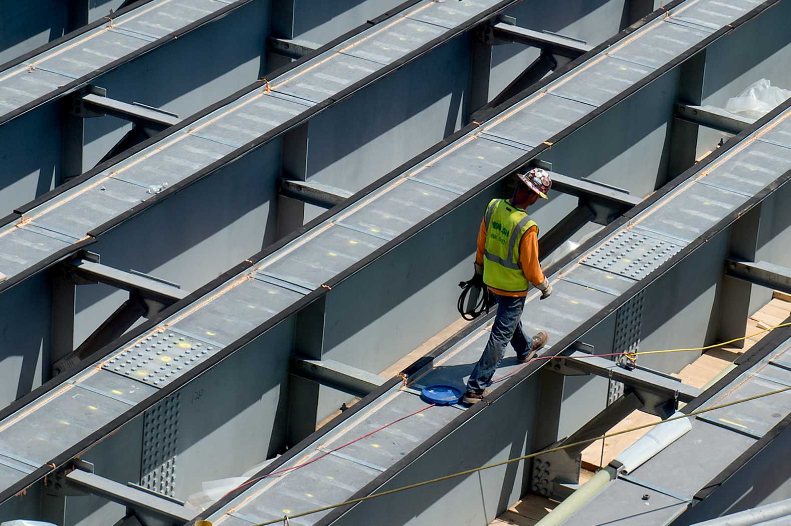 A construction worker walks along a steel girder in place for the construction of the Commonwealth Avenue Bridge. PHOTO BY MADDIE MALHOTRA/ DAILY FREE PRESS STAFF