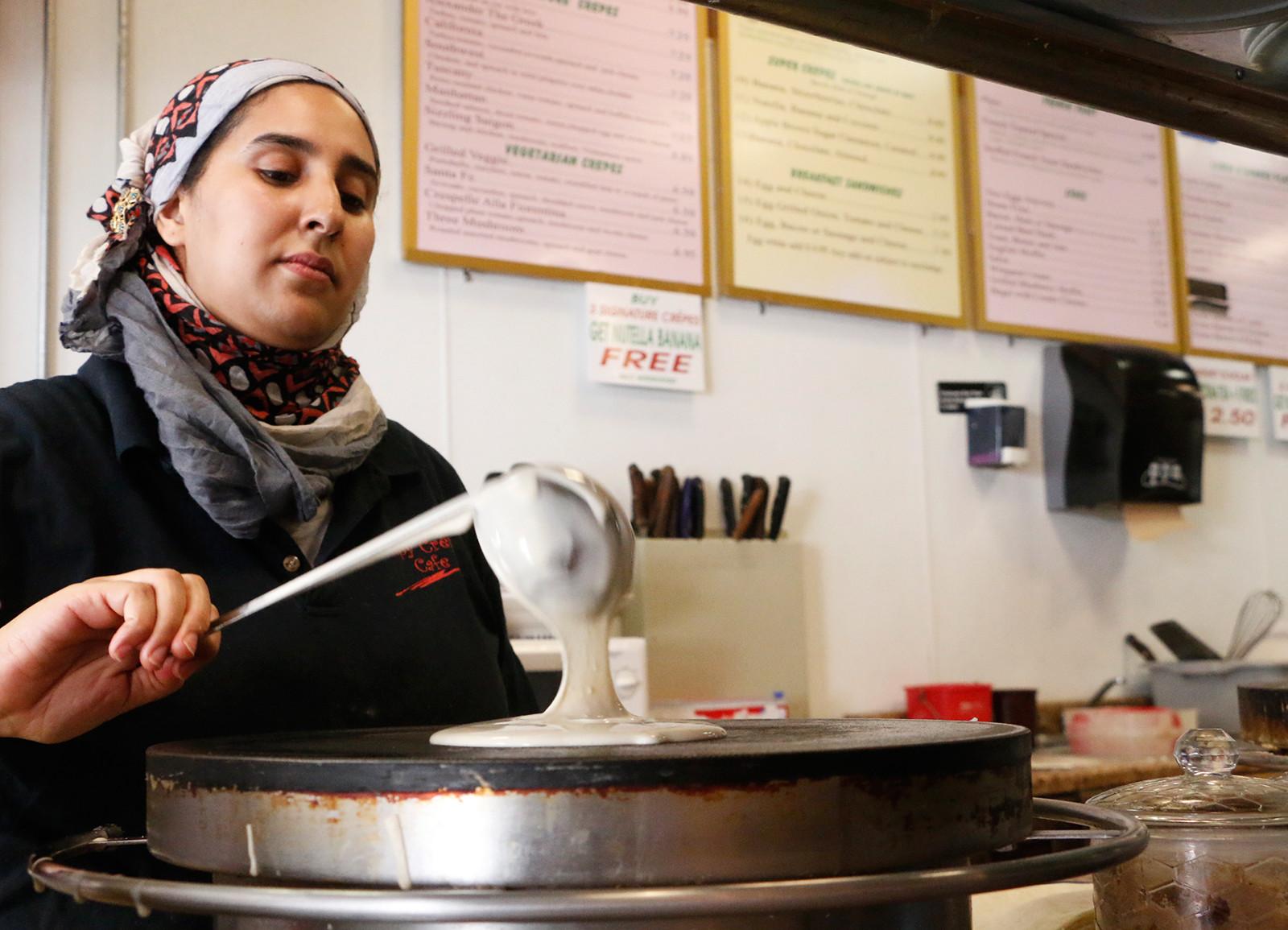 Hanane, of Crispy Crepes Café, pours a crepe for a customer Wednesday afternoon.  PHOTO BY OLIVIA NADEL/DAILY FREE PRESS STAFF